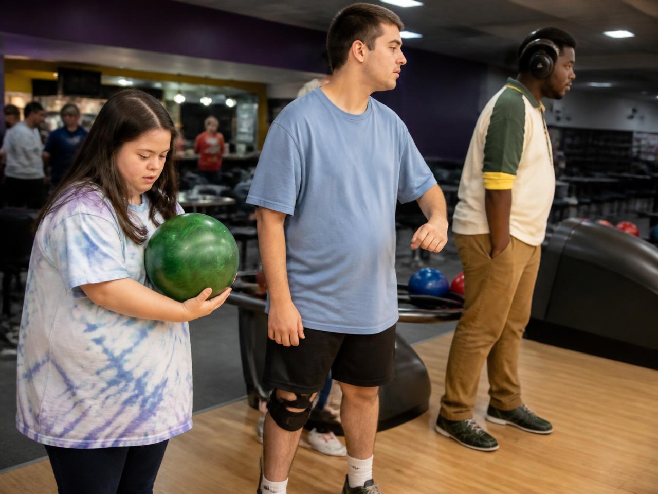 Adults lining up a shot at a neighborhood bowling alley